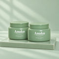 Two Anuko Nourishing Hair Butter jars on a celadon tile plinth