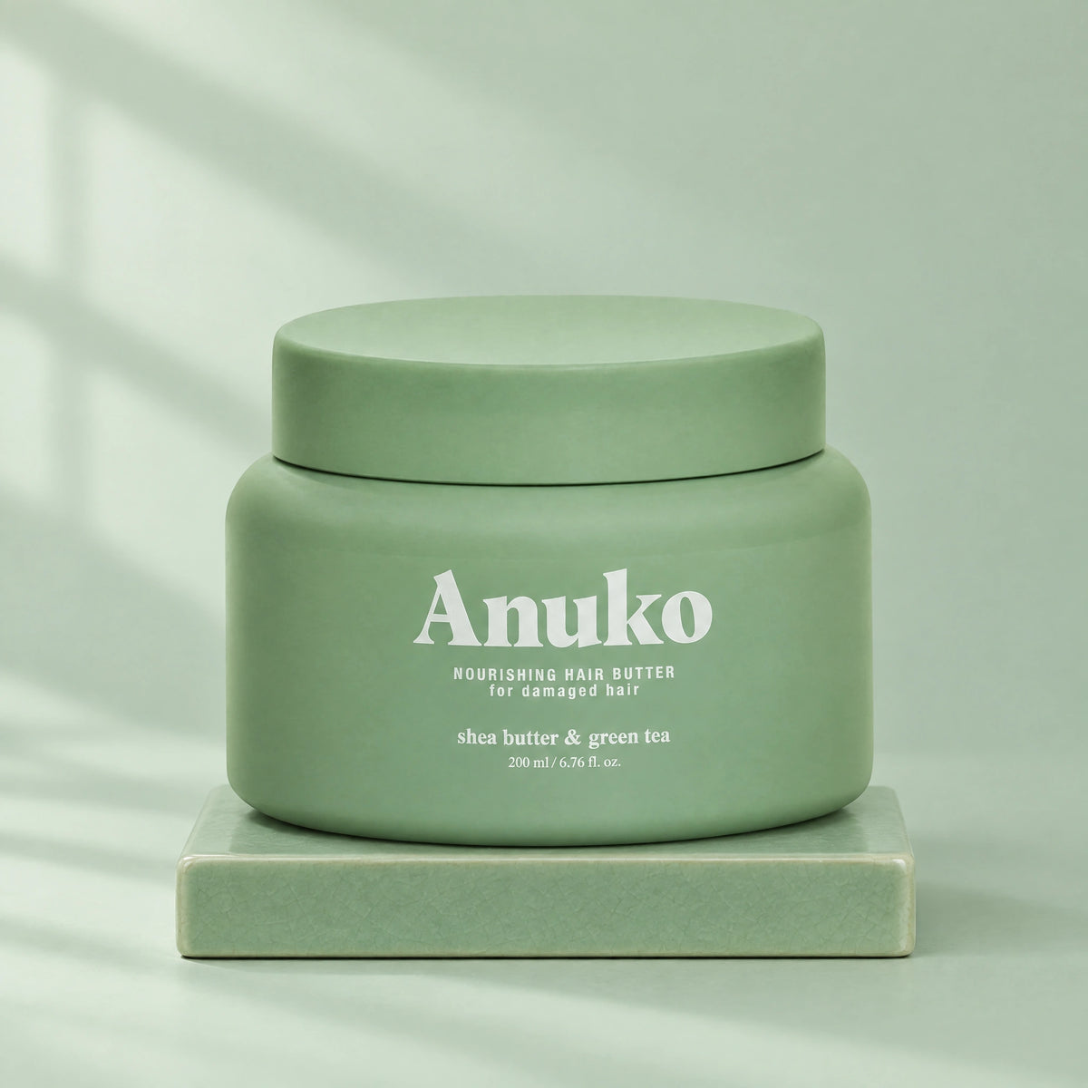 Anuko Nourishing Hair Butter 200 ml jar on a celadon tile plinth