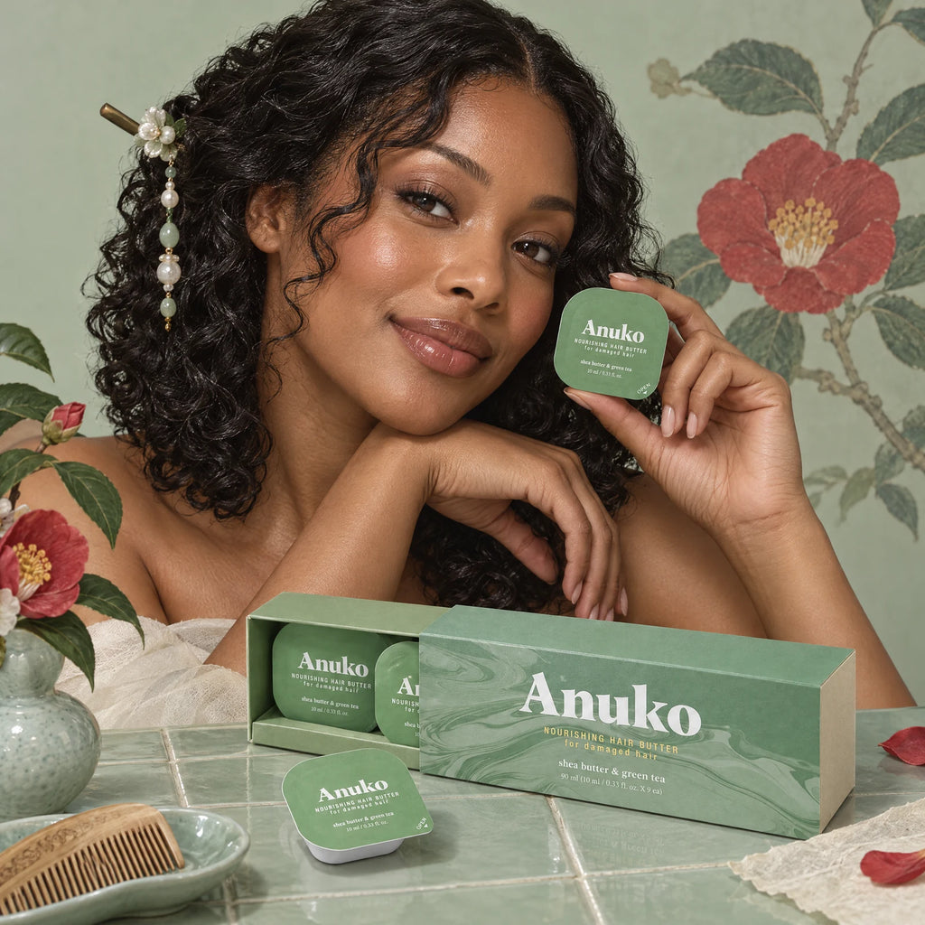 Woman with glossy curls holding a Travel Hair Butter capsule