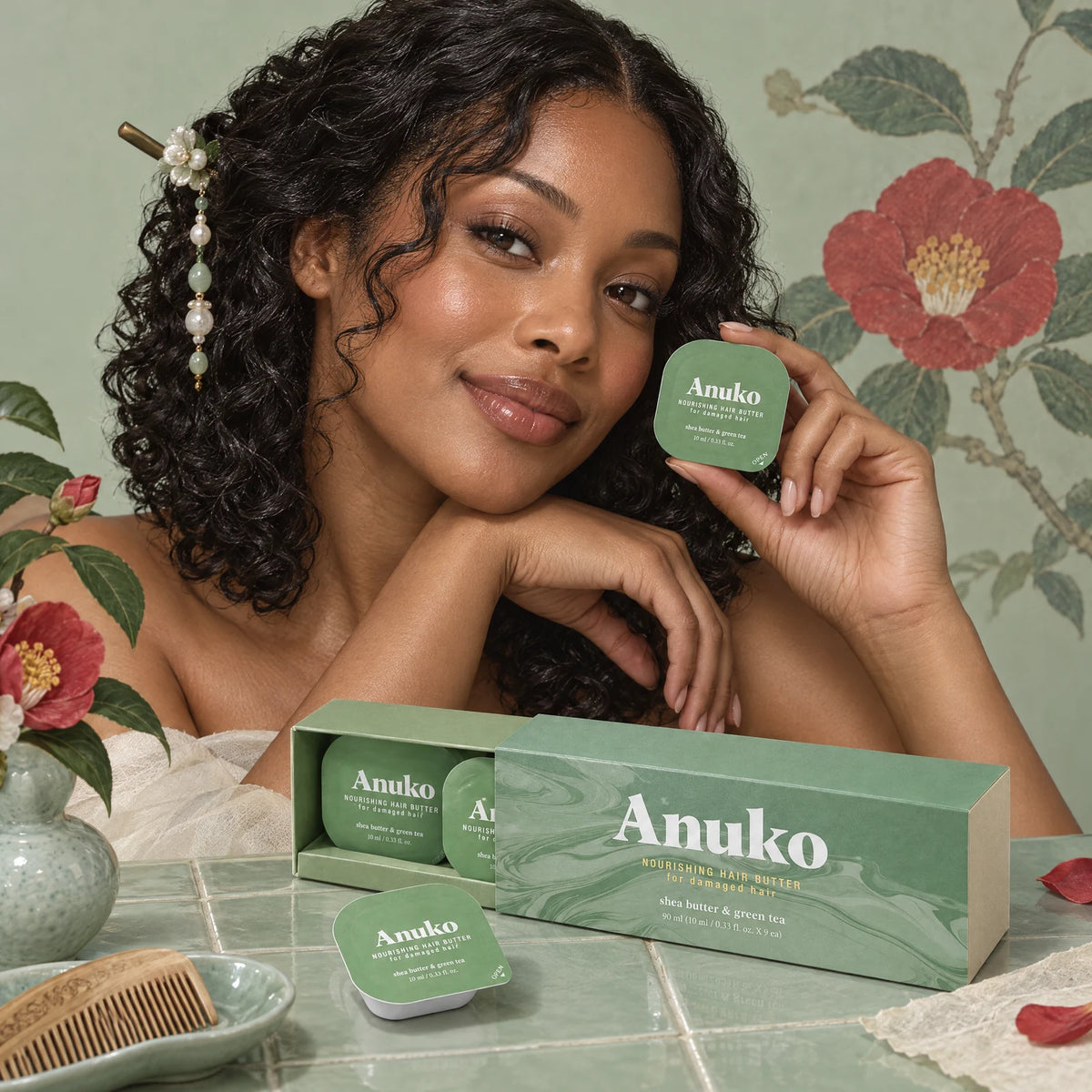 Woman with glossy curls holding a Travel Hair Butter capsule