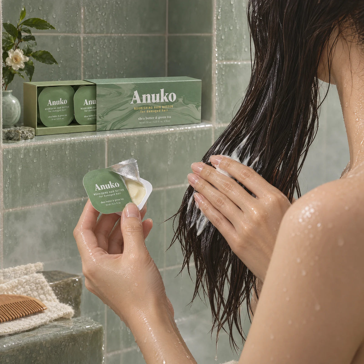 Hands smoothing Hair Butter from a capsule onto wet hair in the shower